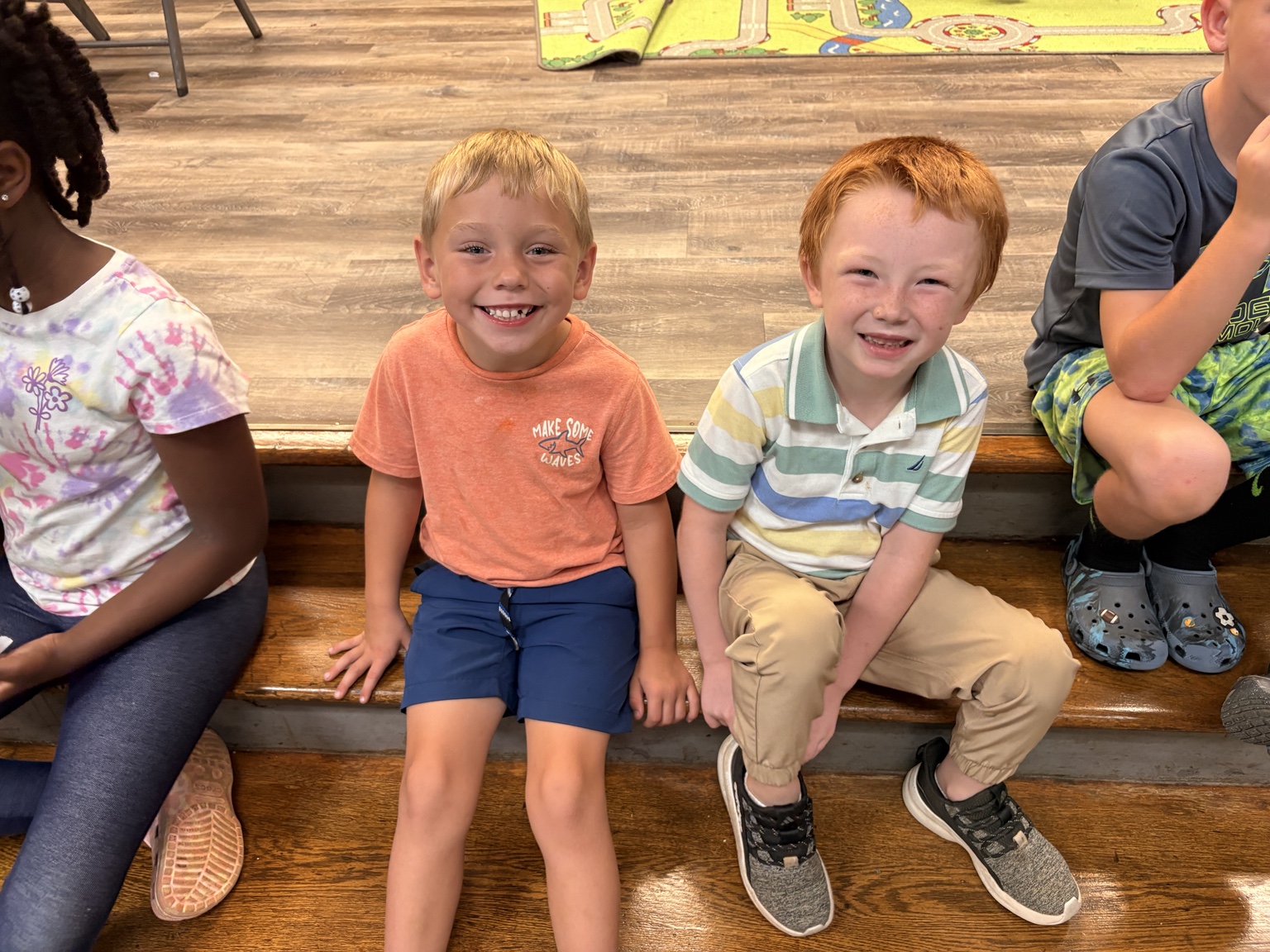 Two smiling boys sitting together during an afterschool break