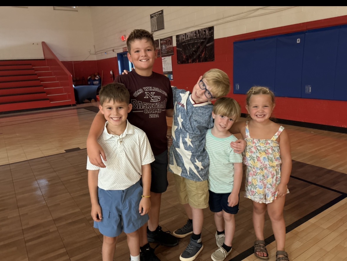 Five children smiling together in the gym