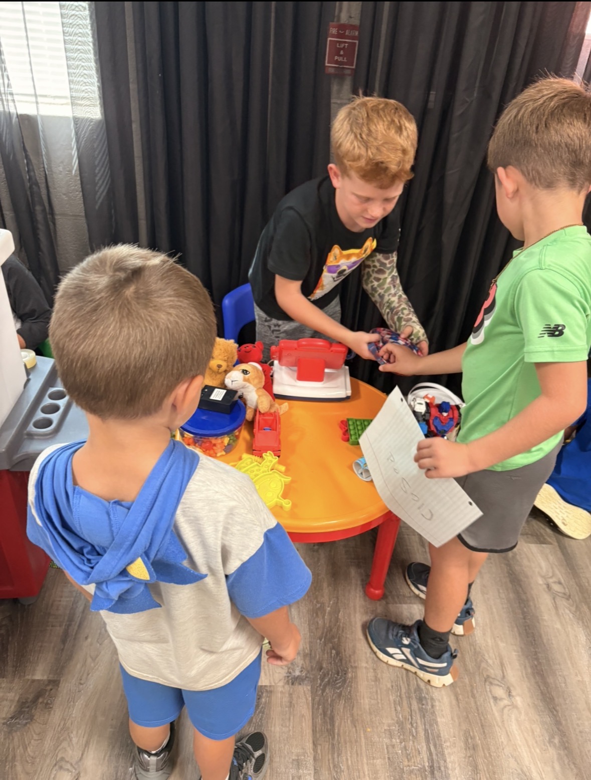 Children sharing toys around an activity table