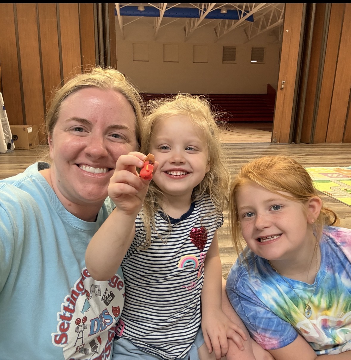 Staff member smiling with two children